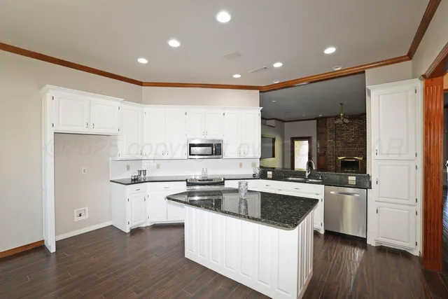 a kitchen with white cabinets sink and stainless steel appliances