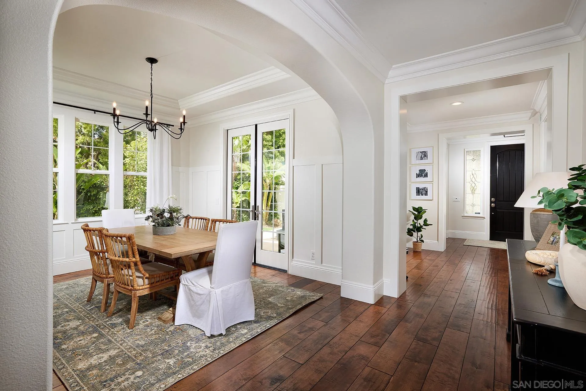 3501 Corte Romero Carlsbad, CA 92009 - Photo 9 of 48 a dining room with wooden floor a chandelier a wooden table and chairs
