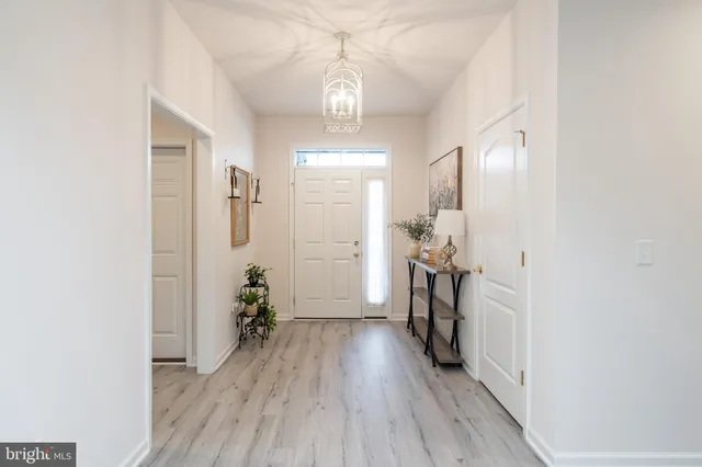 a view of a hallway with wooden floor and a bathroom