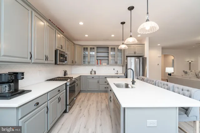 a kitchen with kitchen island granite countertop a sink a counter space appliances and cabinets