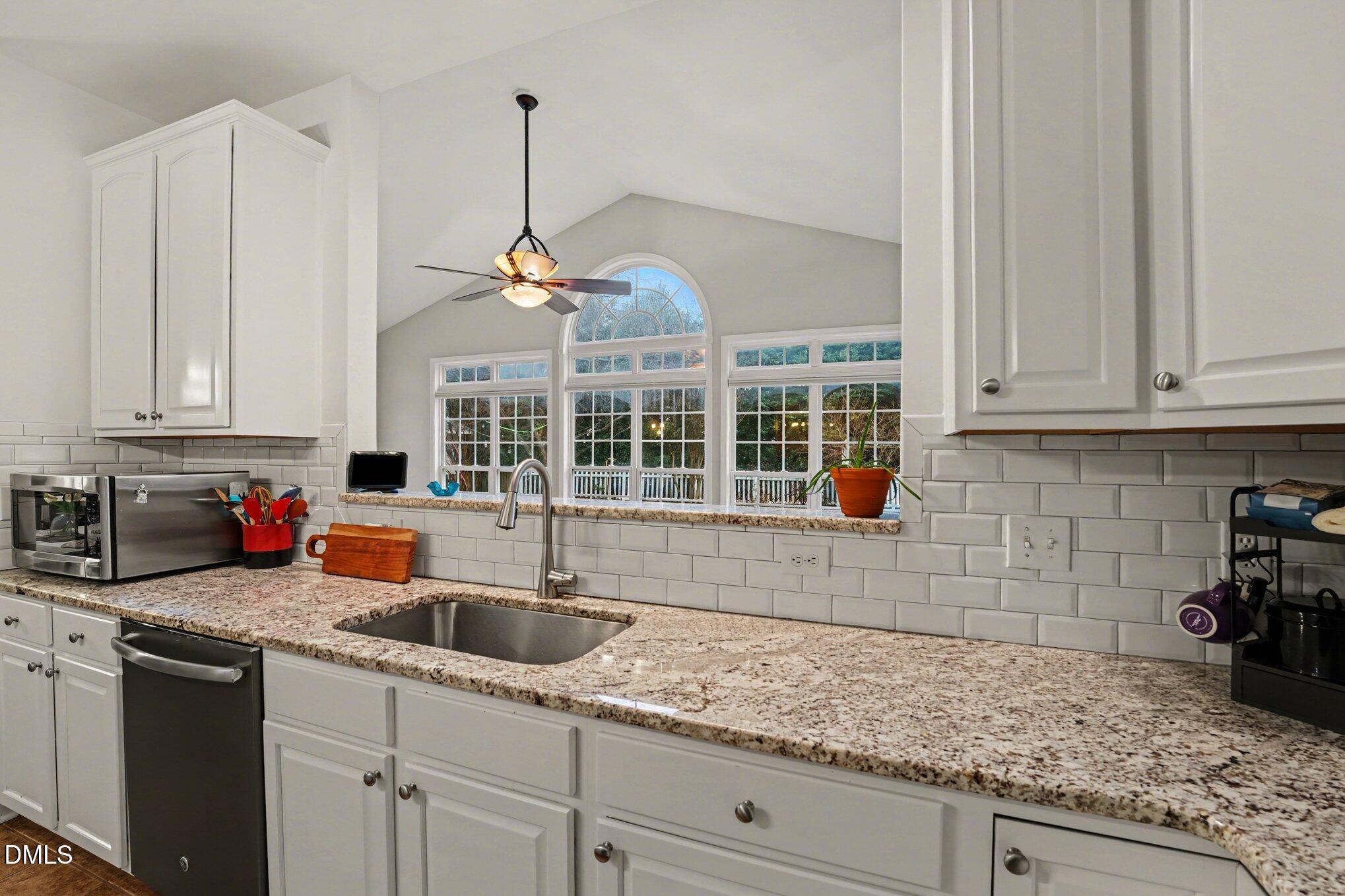 2505 Wyatt Lane Raleigh, NC 27614 - Photo 13 of 54 a kitchen with stainless steel appliances granite countertop a sink a stove and white cabinets