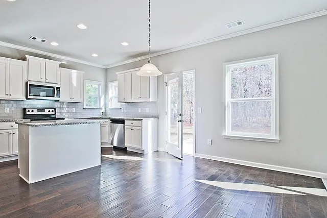 a kitchen with granite countertop a refrigerator stove top oven and sink