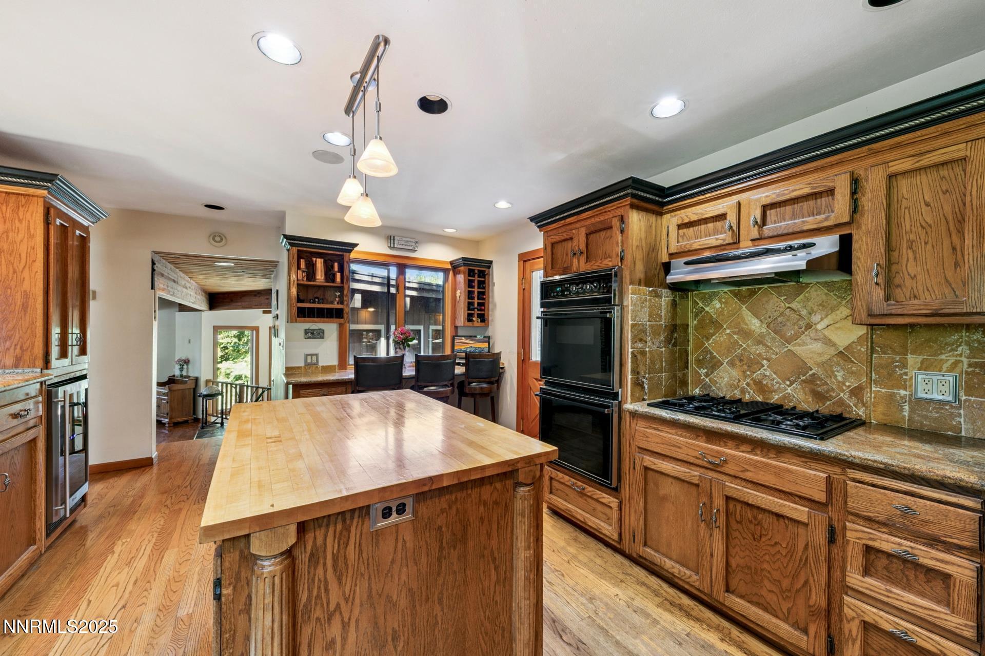 173 Hall Court Stateline, NV 89449 - Photo 13 of 32 a kitchen with stainless steel appliances kitchen island granite countertop a refrigerator a stove top oven a sink with island and chairs