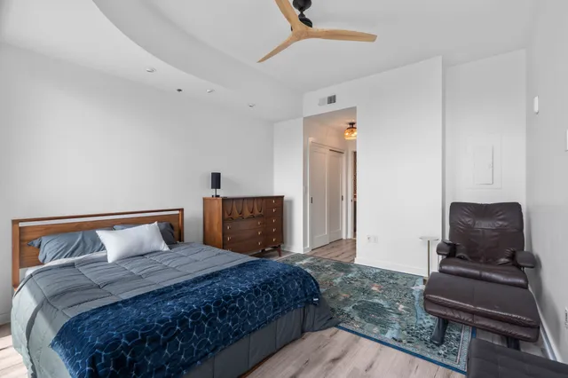 a spacious bedroom with a bed and wooden floor