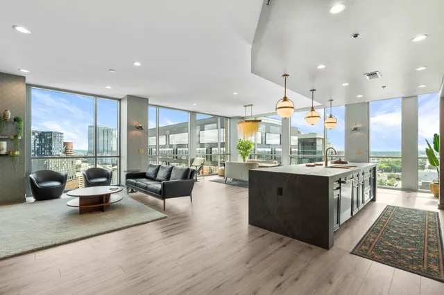 a open kitchen with stainless steel appliances granite countertop a lot of living room and couches