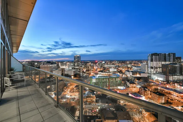 an aerial view of a residential houses with outdoor space and trees all around