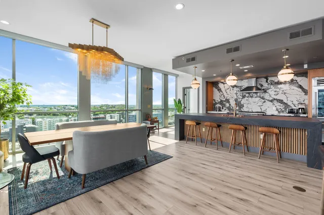a living room with furniture a floor to ceiling window and wooden floor