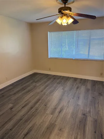 a view of room with wooden floor and fan