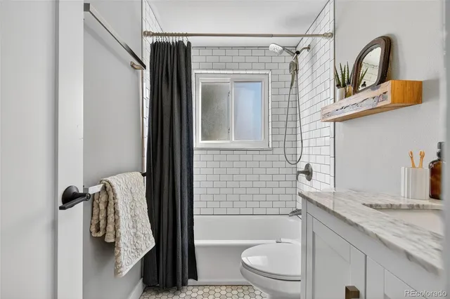 a bathroom with a granite countertop sink toilet and shower