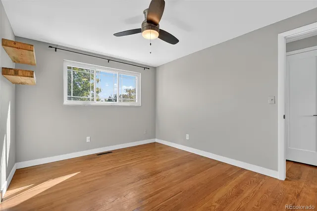 a view of empty room with wooden floor