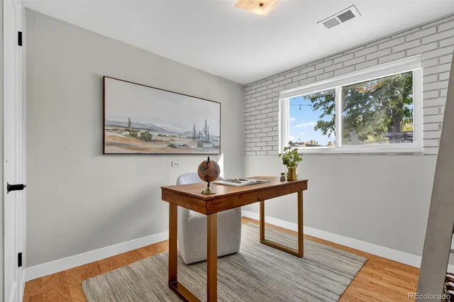 a view of a workspace with wooden floor and a window