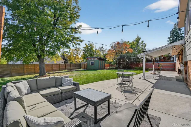a view of a patio with couches and a table and chairs with garden view