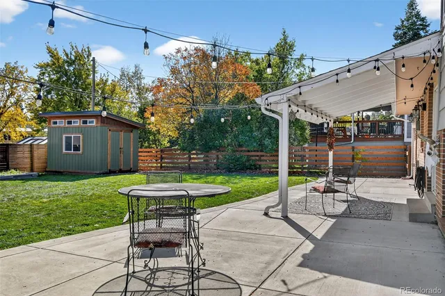 a view of a backyard with table and chairs potted plants and a palm tree