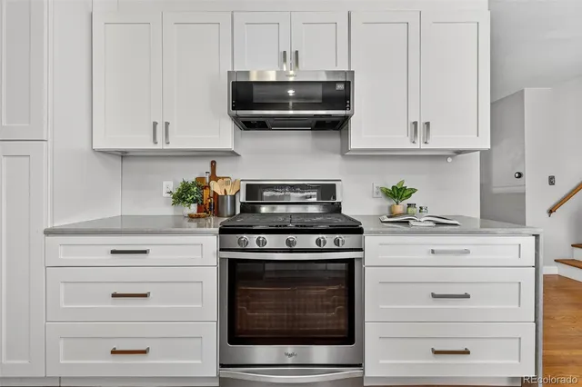 a kitchen with white cabinets and black appliances