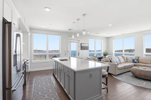 a large white kitchen with a large window and stainless steel appliances
