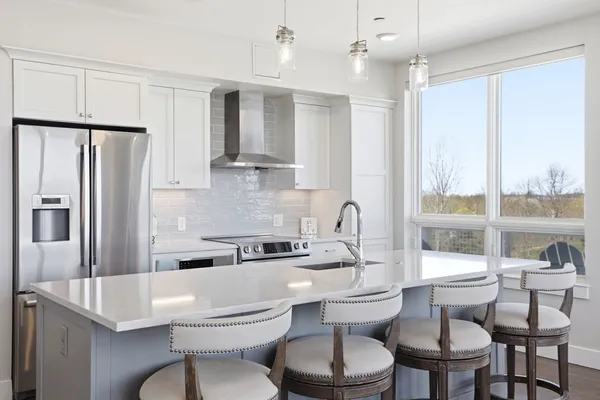 a kitchen with a table chairs stove and refrigerator