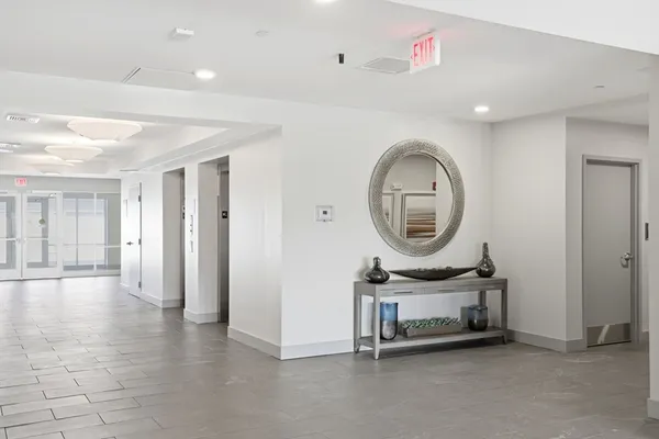 a living room with furniture a mirror and a clock