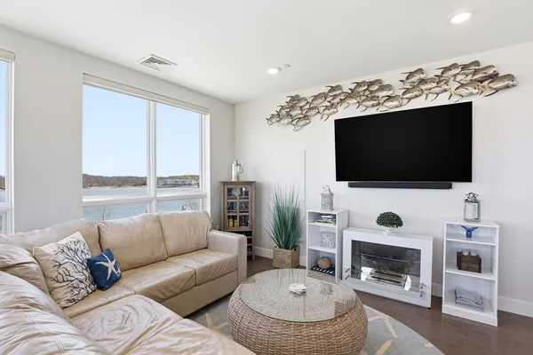 a living room with furniture a flat screen tv and a fireplace