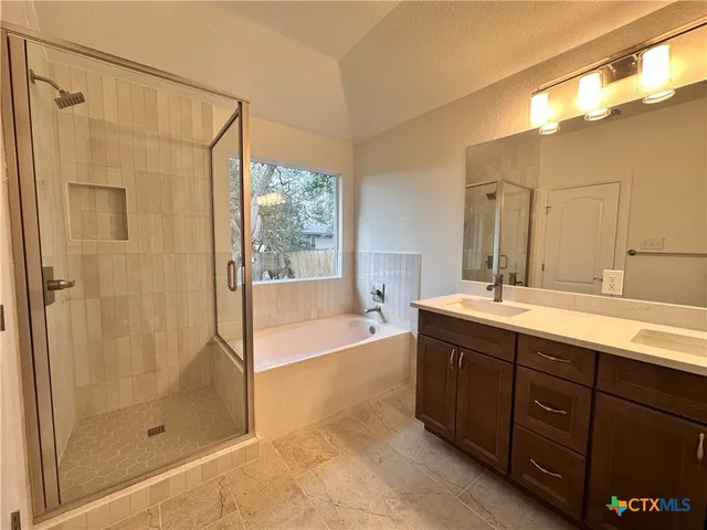 an empty room with wooden floor ceiling fan and windows