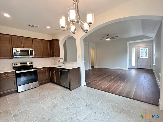 a kitchen with stainless steel appliances granite countertop a stove microwave and sink