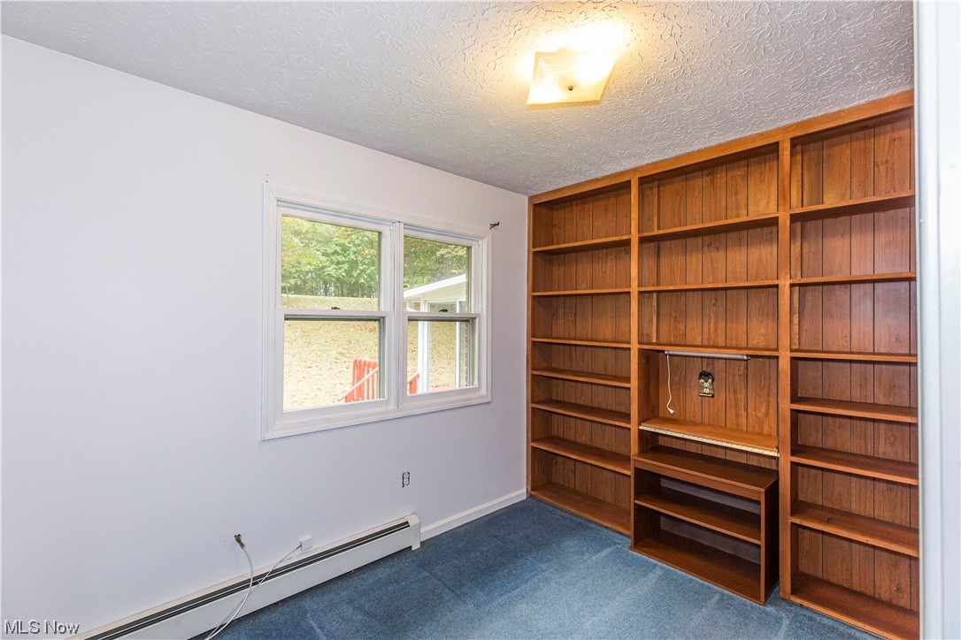 3077 Luli Road Mogadore, OH 44260 - Photo 17 of 34 Carpeted empty room with baseboard heating and a textured ceiling