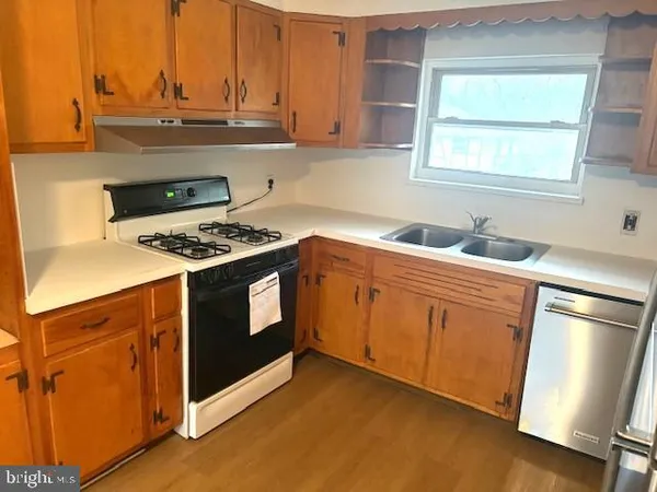 a kitchen with stainless steel appliances a stove a sink and a microwave
