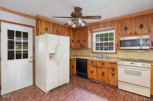 812 Stallings Road Durham, NC 27703 - Photo 10 of 19 a kitchen with wooden cabinets and white appliances