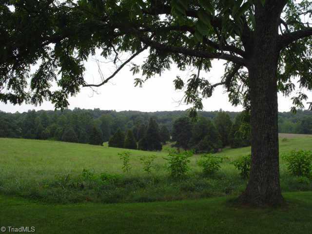 702 Anderson Road Siloam, NC 27047 - Photo 1 of 9 Exterior Front. View of Farm from under Walnut Tree