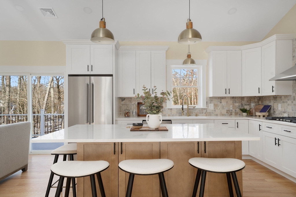 660 Pine Street Seekonk, MA 02771 - Photo 4 of 37 a kitchen with stainless steel appliances granite countertop a table chairs stove and white cabinets