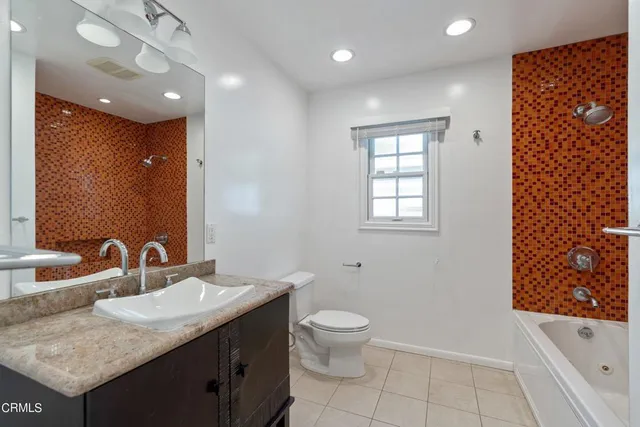 a bathroom with a granite countertop sink a toilet and shower