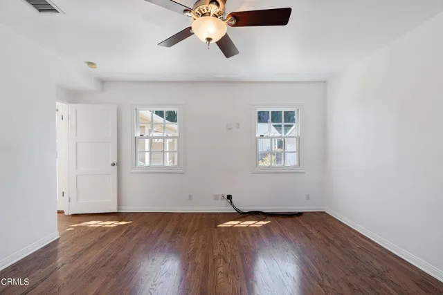 a view of empty room with wooden floor