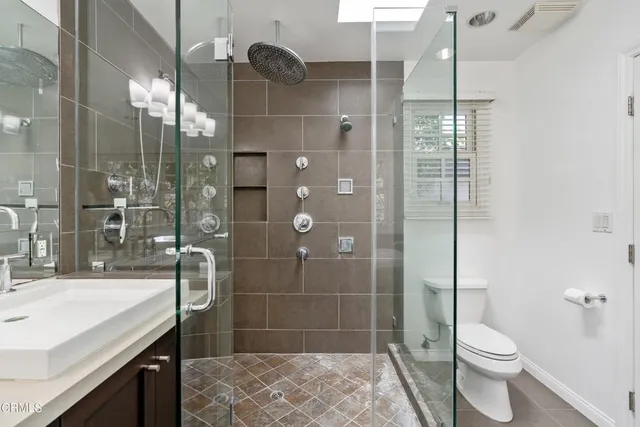 a bathroom with a sink a toilet and shower