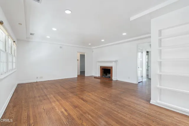 a view of empty room with wooden floor and fireplace