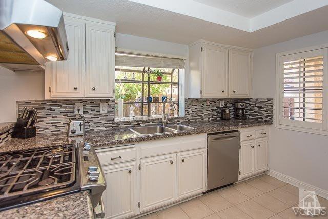 5833 Cochran Street Simi Valley, CA 93063 - Photo 4 of 28 a kitchen with granite countertop white cabinets and window