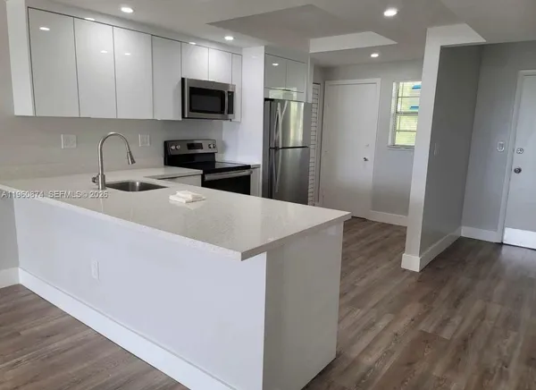 a kitchen with granite countertop a refrigerator and a sink