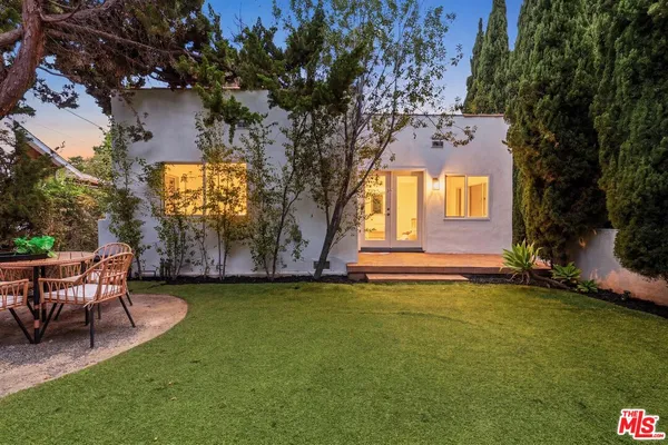 a view of a house with a yard and a tree