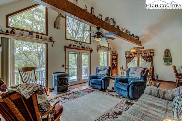 a living room with furniture a flat screen tv and a floor to ceiling window