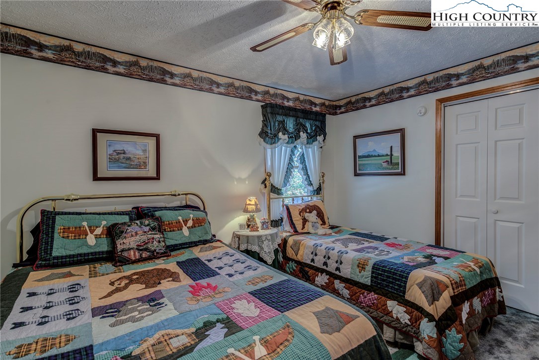 2164 River Bend Road Mouth Of Wilson, VA 24363 - Photo 25 of 50 a bedroom with bed and a chandelier