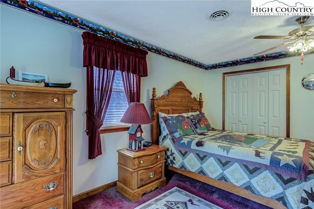 a bedroom with double bunk beds ceiling fan and windows