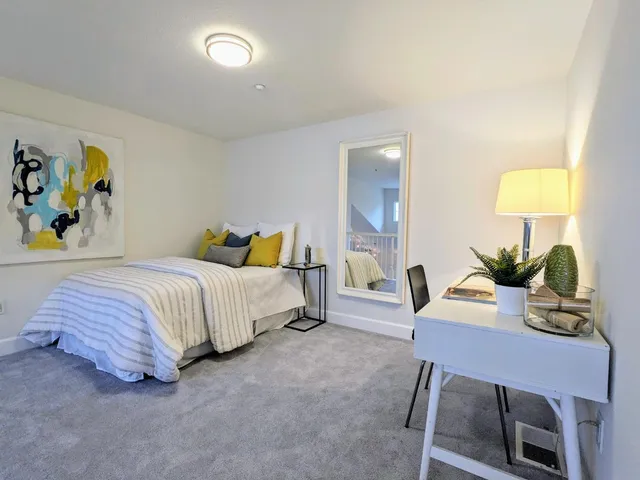 a bedroom with a bed a table and painting on the wall