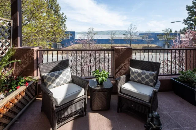 a view of a balcony with two chairs and a potted plant