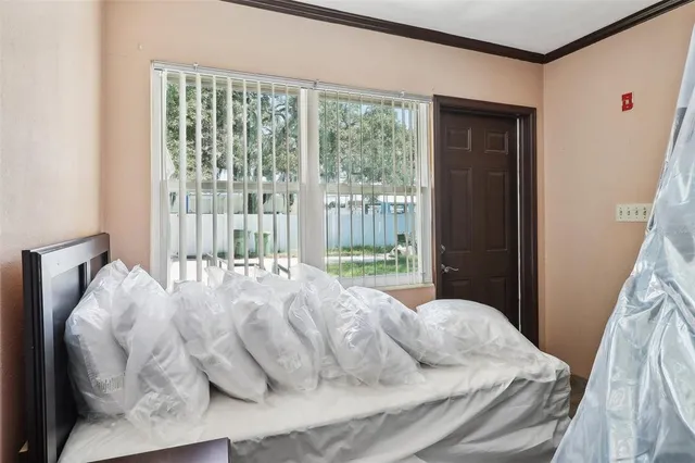a large bed sitting in a bedroom next to a window