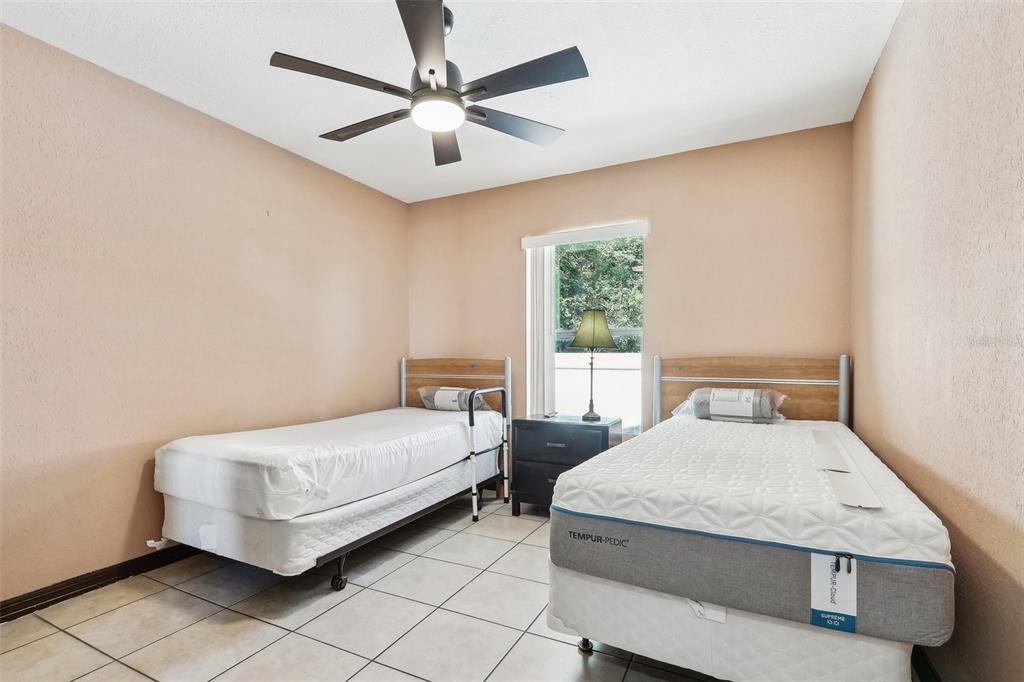 201 Rosefield Avenue Leesburg, FL 34748 - Photo 27 of 43 a bedroom with a bed and a chandelier