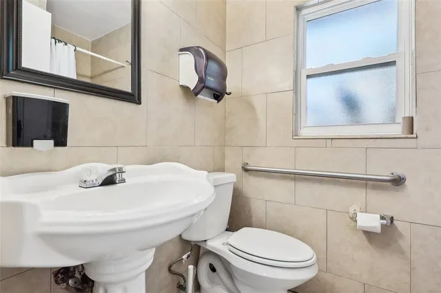 a bathroom with a toilet a sink and mirror