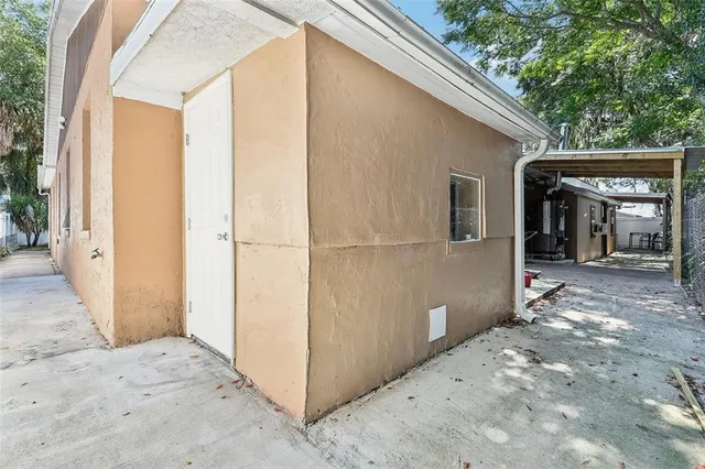 a patio with table and chairs and potted plants