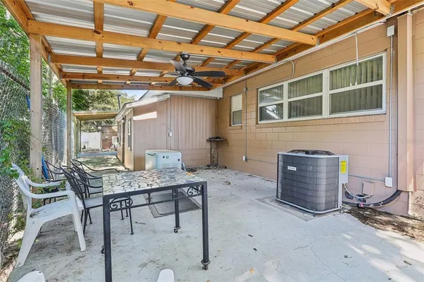 a view of a patio with table and chairs and barbeque