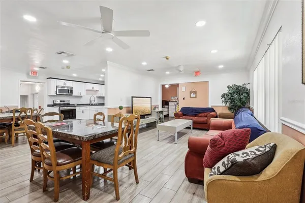 a living room with furniture kitchen view and a chandelier