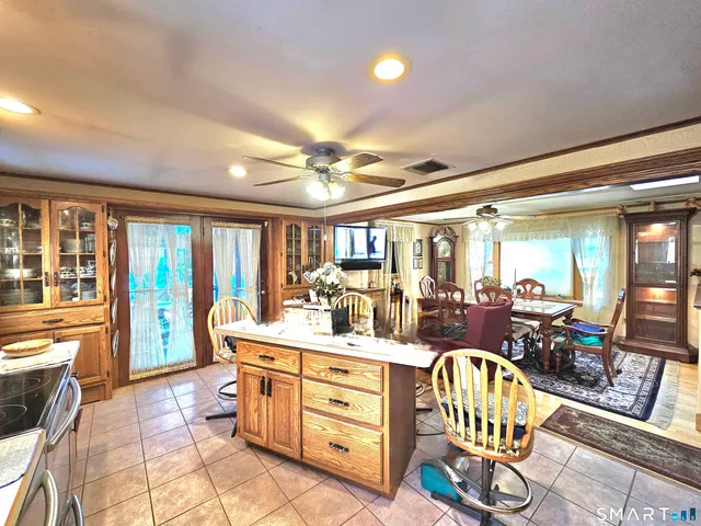 a room with stainless steel appliances kitchen island granite countertop a sink and cabinets