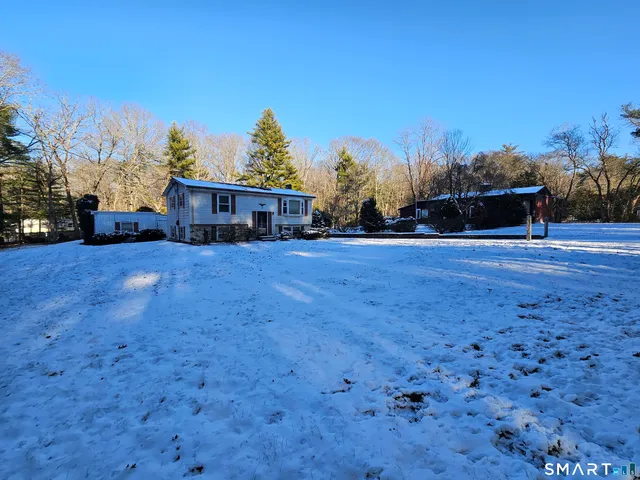 a view of a house with a yard and sitting area
