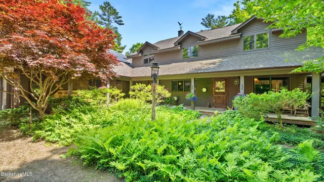 a view of a house with a yard and potted plants